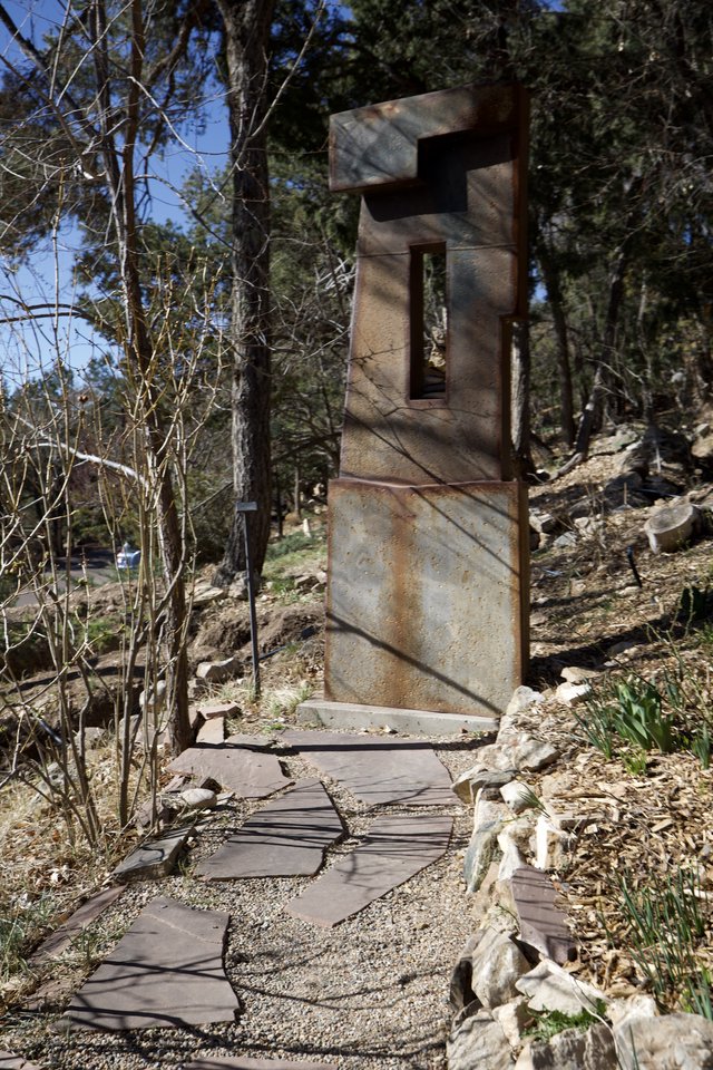 Weathered Metal Sculpture Gateway in Forest Garden