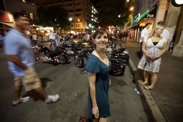 Woman Smiling on Lively Austin Street at Night