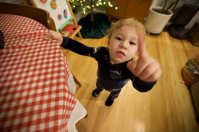 Toddler Pointing at Camera in Cozy Home Setting