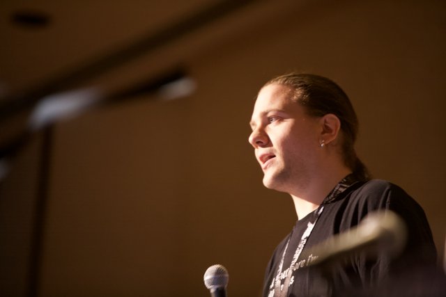 Rocking the Mic Caption: A long-haired man captivates the crowd with his electrifying speech at the 2009 Defcon 17 conference.