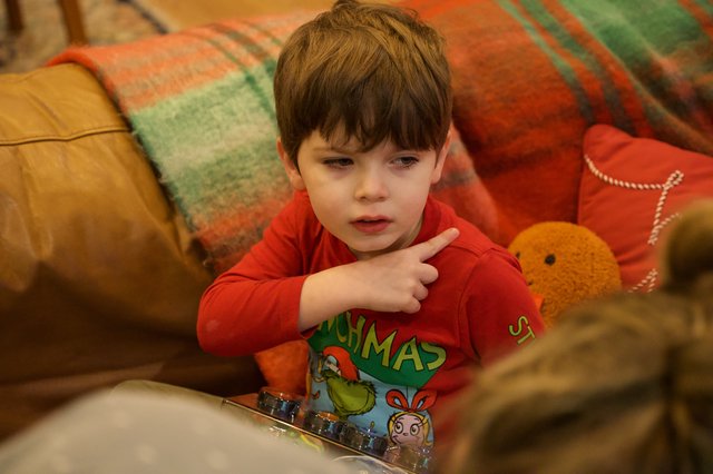 Young Boy in Christmas Pajamas Engaged with Device