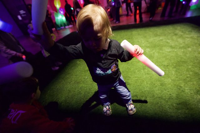 Child Dancing with Glow Stick at Baby Rave Event
