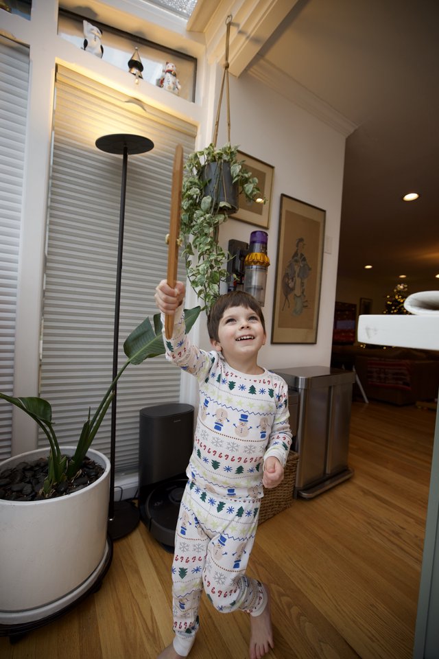 Joyful Child Playing with Wooden Sword in Cozy Home