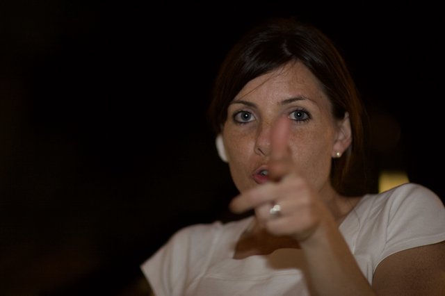 Woman Pointing with Intent in Dark Setting