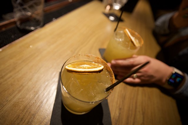 Craft Cocktails with Citrus Garnish on Wooden Bar