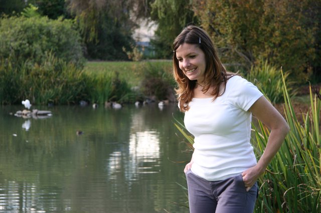 Woman Smiling by a Tranquil Park Pond