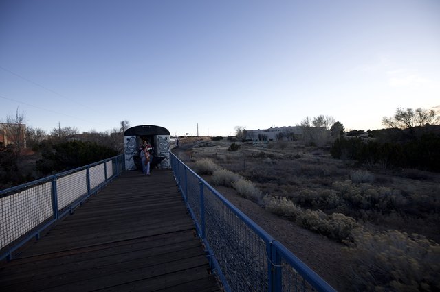 Twilight Walk on Blue Pedestrian Bridge in Desert Landscape