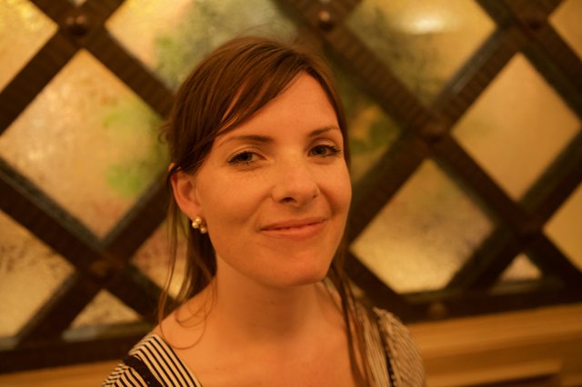 Warm Portrait of Woman Before Latticed Glass Window