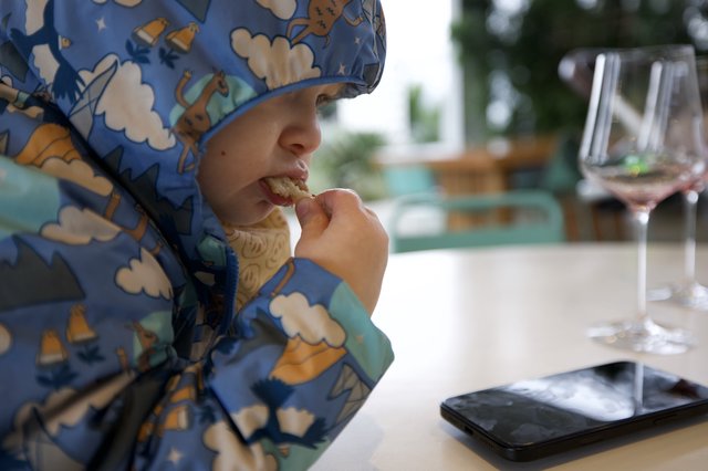 Young Child Enjoying Meal at Restaurant Table