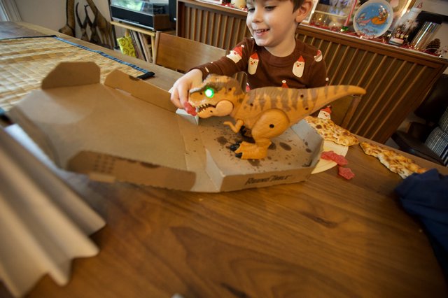 Child Playing with Dinosaur Toy at Christmas Pizza Dinner