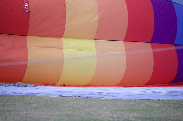 Rainbow Hot Air Balloon Inflating on Grass Field
