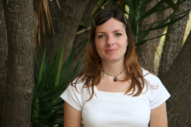 Woman Smiling Outdoors Among Tropical Trees