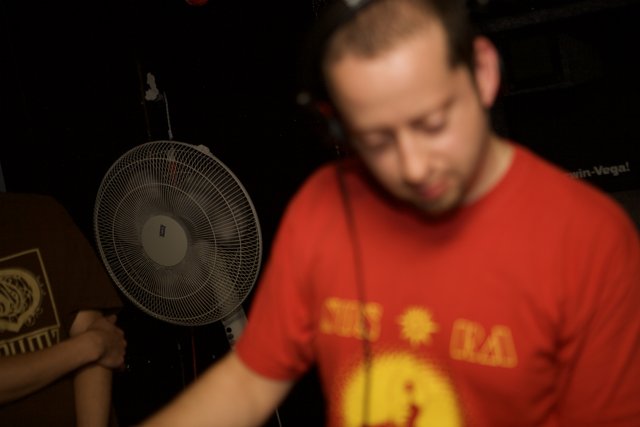 Red-shirted man spinning tunes