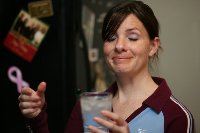 Woman with Drink Gives Thumbs Up at Party