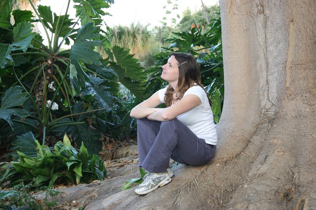 Contemplative Woman Resting Against Ancient Tree Roots