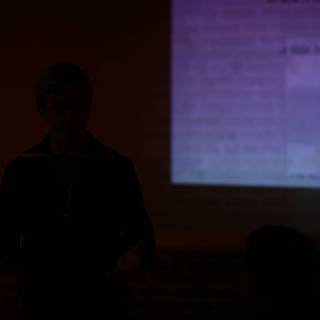 Man presenting in front of a projection screen