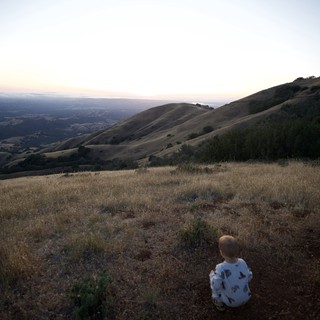 Two Toddlers Gaze Over Golden Hills at Dusk