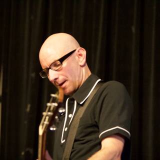 Bald Man with Glasses Strums a Tune