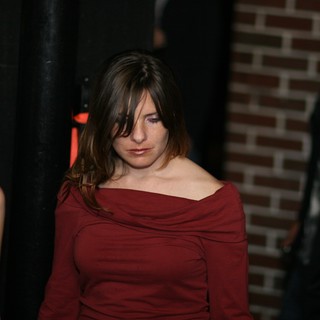 Contemplative Woman in Red at Dimly Lit Venue