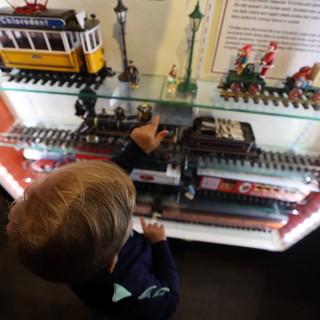 Child Exploring Miniature Train Display at Museum