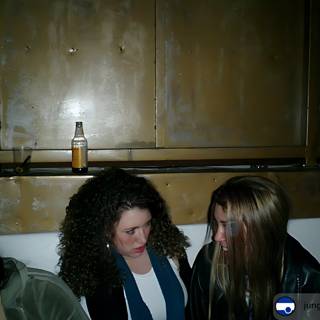 Two women enjoying a drink in a dark room