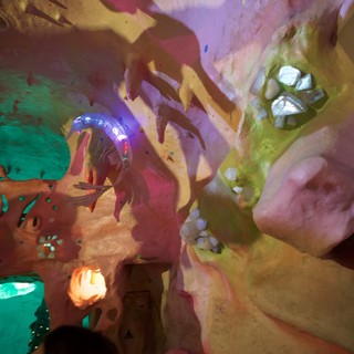 Illuminated Fantasy Cave Interior with Colorful Sculptures