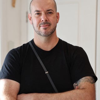 Confident Portrait of Bald Man with Tattoo in Modern Interior