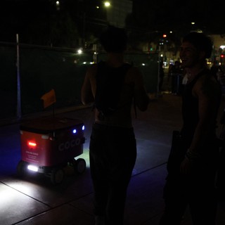 Coco Delivery Robot Encounters Festival Goers at Night