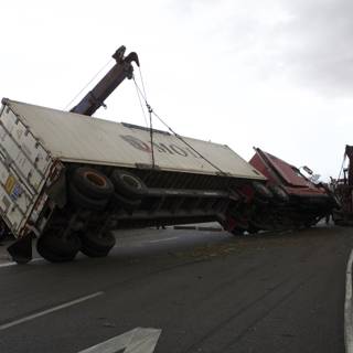 Crane lifts overturned truck on busy road