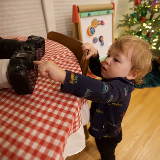 Young Child Exploring Professional Camera Equipment at Christmas