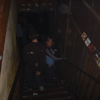Friends Descending Dimly Lit Venue Staircase at Night