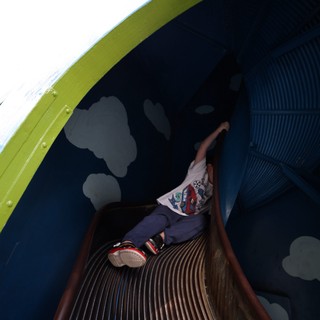 Child Descending Through Colorful Tunnel Slide