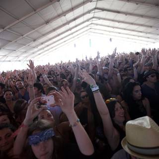 Crowd Goes Wild Caption: Excitement rises as festival-goers raise their hands in the air to the beat of the music at the 2012 Coachella music festival. Caroline de Maigret, Scott Russell, Tyson Heung, and Pier Silvio Berlusconi (pictured) join in the fun with their stylish hats and accessories.