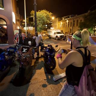 Woman poses with motorcycle at night