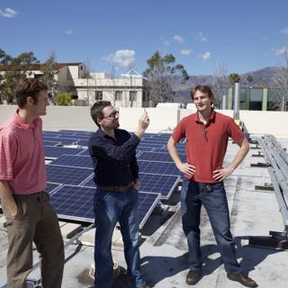 Three Men Installing Solar Panels on a Rooftop