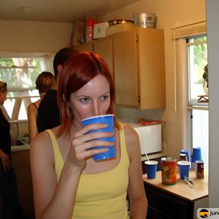 Red-haired woman enjoying a beverage in the kitchen