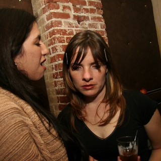 Two Women Conversing at a Dimly Lit Bar