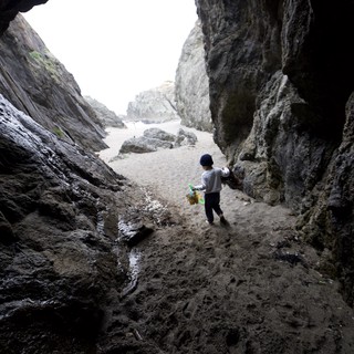 Child Explorer Ventures Through Coastal Sea Cave