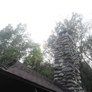 Slate-roofed stone chimney in rural setting
