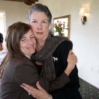 Two Women Share Emotional Embrace at Funeral Reception
