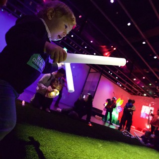Child Playing with Light Tube at Baby Rave Event