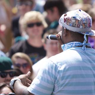 Man in Blue Shirt and Hat Performing at Coachella Music Festival
