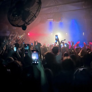 Concert Crowd with Phones Raised in Hazy Blue Light