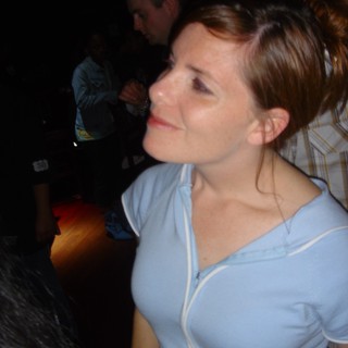Woman Smiling Upward at Dimly Lit Venue