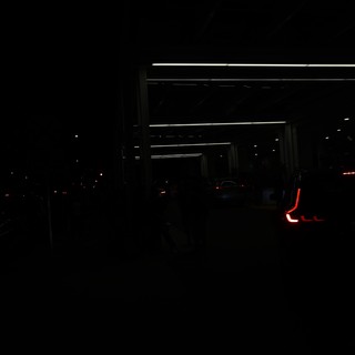 Red Taillights Glow in Dark Parking Structure Night