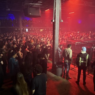 Red-Lit Concert Crowd from Side Stage View