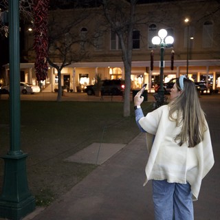 Woman Photographing Plaza Decorations at Night in Santa Fe