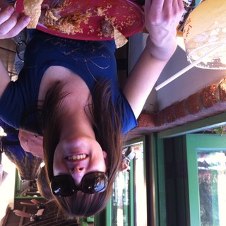 Woman Smiling Over Mexican Food at Outdoor Restaurant