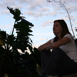 Woman Contemplating at Dusk Among Tropical Foliage