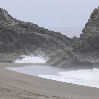 Crashing Waves Through Rocky Coastal Cliffs